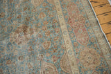 Distressed vintage Tabriz carpet: dusty wine red cartouche border and textured pile.