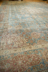 Distressed Tabriz carpet with worn pile, faded blue field, and dusty wine cartouche border.