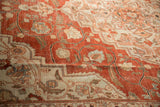 Angled view of the distressed Khoy carpet's evenly worn pile with floral motifs in brick red.