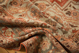 Soft folds showing the low, even wear and terracotta floral details of a vintage Khoy carpet.