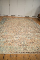 Distressed Mehrivan carpet corner with worn beige, sand, blue geometric florals, samovar border, and fringe.