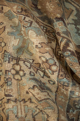 Distressed vintage Mehrivan carpet's textured pile, showing geometric floral motifs and soft hues.