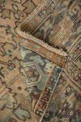 Distressed pile texture of Mehrivan carpet corner, showing beige, teal geometric floral motifs.