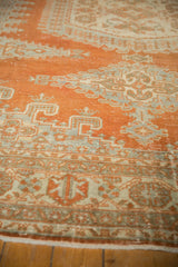 Distressed texture revealing faint foundation in rust tangerine and ivory patterns.
