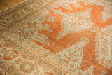 Pale rust tangerine, slate grey geometric patterns of a distressed Veece carpet with even wear.
