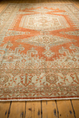 Distressed Veece carpet fringe and geometric border in rust orange and ivory tones.
