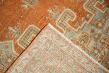 Distressed vintage Veece rug's tangerine orange pile and visible hand-knotted foundation.