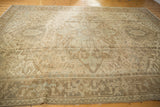 Distressed vintage Heriz rug section, geometric patterns with time-softened bronze and ivory.