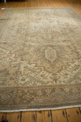 Secured end and geometric border of the distressed Heriz carpet, revealing wear and muted earth tones.