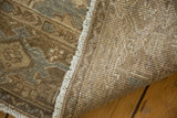 Close-up of distressed Heriz rug showcasing pile wear, secured fringe, and hand-knotted foundation.
