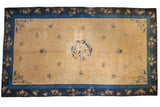 Vintage Peking carpet with a bird medallion, open golden field, and intricate indigo floral borders.