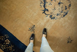 Low pile texture and indigo blue pictorial details on a dusty gold vintage Chinese Peking carpet.