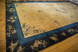 Angled view of a vintage Peking carpet's corner showing its deep indigo border and scattered floral sprays.