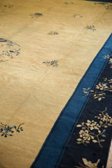Time-softened dusty gold field and indigo floral border of a vintage Peking carpet.