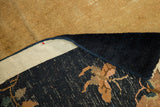 A corner view reveals the hand-knotted back and secured ivory edge of a vintage Peking rug.