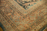 Worn texture of a distressed Mahal carpet corner with terracotta and dusty blue floral borders.