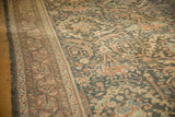 Angled view of a vintage Mahal carpet highlighting its even wear and scrolling floral vinery.