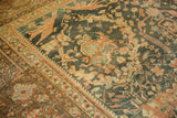 Detailed texture of a distressed Mahal carpet with blush and dusty blue floral motifs on a charcoal field.