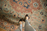 Distressed Tabriz carpet with seafoam green, pale rust, and navy floral motifs, showing even wear.