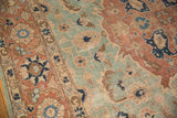 Distressed vintage Tabriz rug showing seafoam green, pale rust, and navy serrated leaf patterns.