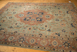 Distressed vintage Tabriz rug section with seafoam, pale rust, and navy floral motifs.