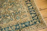 Distressed Hamadan runner showing intricate indigo blue border with beige motifs.