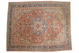 Antique Serapi carpet featuring a concentric medallion, navy blue, brick red, and floral vinery.