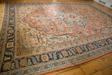 Intricate floral vinery and scalloped medallion of an antique Persian Serapi rug.