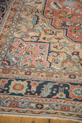 Antique Serapi carpet showing detailed floral vinery, blush quatrefoil, and textured pile.