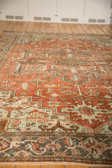 Distressed vintage Heriz carpet showing geometric floral pattern in dusty rust and powder blue.