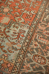 Distressed Heriz carpet showing geometric floral design in dusty rust, powder blue, and silver.