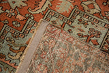 Distressed vintage Heriz pile in terra cotta rust and powder blue, revealing hand-knotted foundation.
