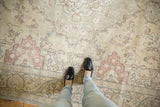 Distressed Tabriz carpet field with worn ivory pile and pale raspberry Rococo design.