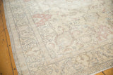 Corner detail of distressed Tabriz carpet with ivory, silver, dusty blush patterns, secured sides.