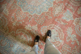 Distressed vintage Mahal carpet featuring faded raspberry and powder blue floral motifs.
