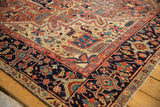 Antique Heriz carpet corner, detailed navy border with geometric vinery and brick red elements.