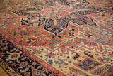 Antique Heriz carpet border detail, featuring geometric vinery and floral elements in navy, brick, and saffron.