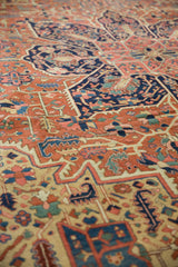 Geometric vinery and blossoms in brick red, navy blue, and saffron on an antique Heriz.