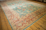 Textured Oushak rug with staggered floral motifs in aqua blue and blush coral.