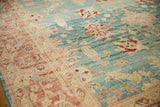 Distressed Oushak carpet with decorative blush coral border and sky blue field showing even wear.