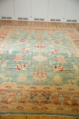Distressed Oushak carpet with aqua blue field, blush coral, and ivory floral patterns.