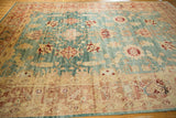 Distressed Turkish Oushak carpet with staggered floral patterns and faint foundation showing through.