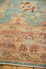 Distressed Oushak carpet, detail of muted sky blue field and rich blush coral border with faded motifs.