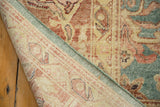 Distressed Oushak rug corner, showing textured pile and hand-knotted foundation.