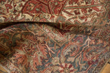 Distressed vintage Heriz carpet with geometric vinery, palmettes, and worn pile revealing foundation.