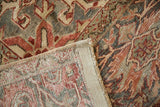 Detailed view of distressed Vintage Heriz carpet pile, showing faint foundation, geometric vinery, and secured edge.