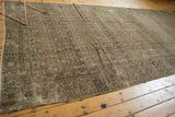Distressed Hamadan rug close-up showing worn Herati motif, secured side, and muted tones.