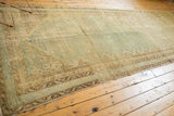 Distressed vintage Malayer carpet with even wear, faded pale blue and sand tones.