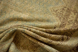 Worn pile of a folded distressed Malayer carpet showing blue and earthy geometric patterns.