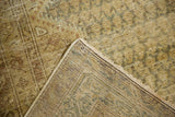Distressed Malayer carpet showing worn pile with visible hand-knotted foundation, in muted tones.